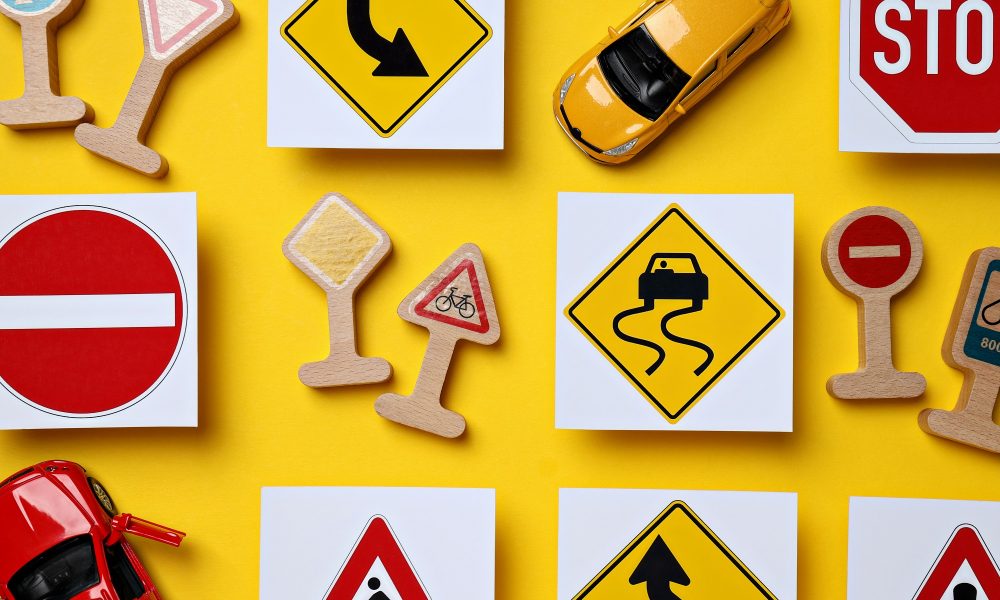 Road signs and vehicles on a yellow background.